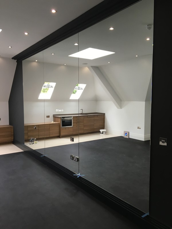Frameless glass partition in loft conversion by Hatfield glaziers